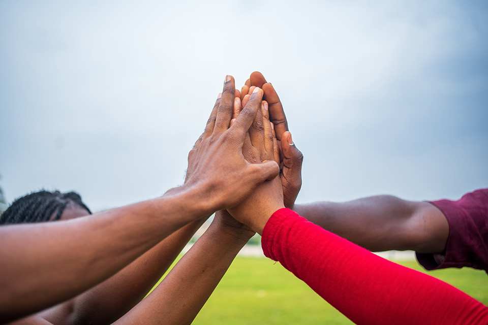 A group of people join hands in solidarity to show support for each other and a single goal.